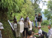 Jalan Sulit Diakses Kendaraan, Bhabinkamtibmas Pikul Kotak Suara Bersama Babinsa dan KPPS